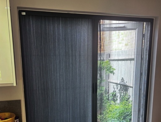 Kitchen French doors in Stourbridge with grey Scene Set fabric pulled across one side and bug-screen mesh on the other, garden visible behind