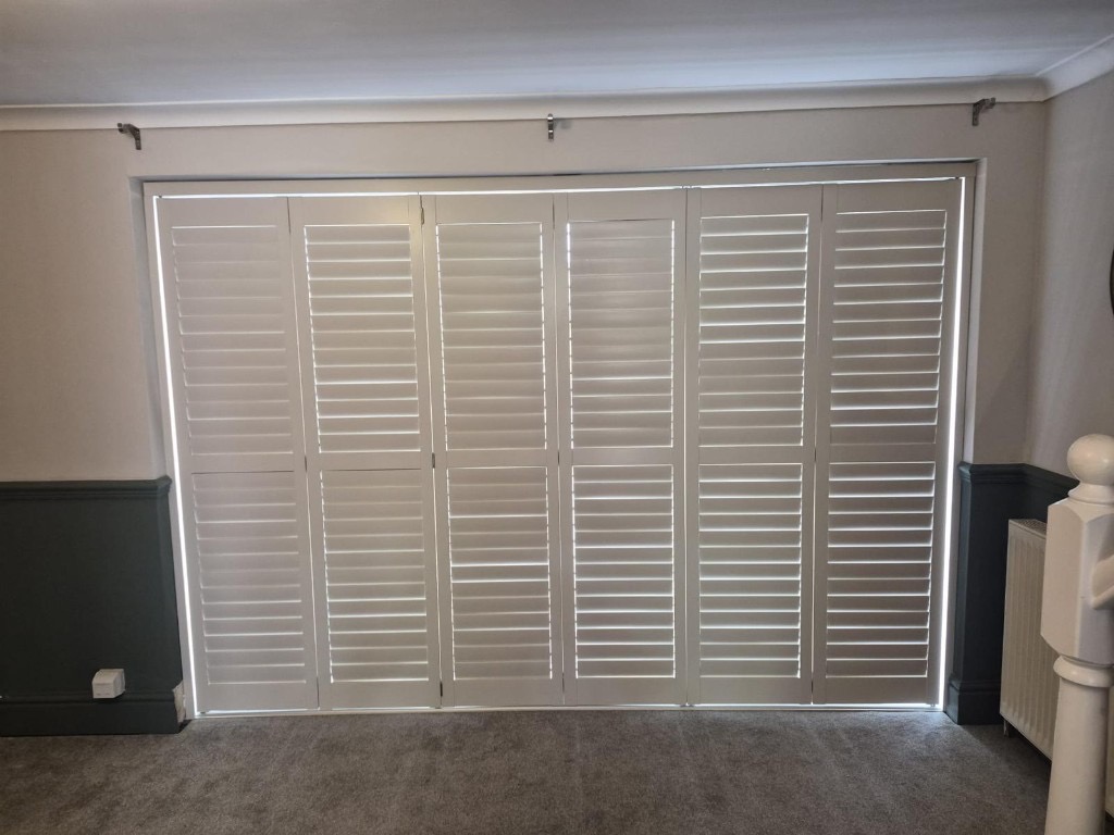 Six-panel tracked shutters in Ivory Lace across sliding doors in Bridgnorth with all louvres closed