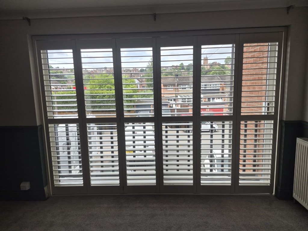 Tracked shutters in Bridgnorth with louvres tilted open, view through to the street outside