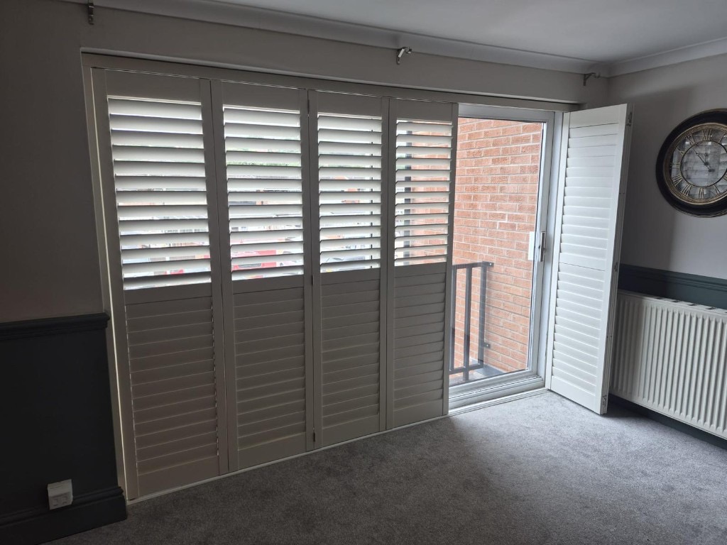Tracked shutters in Bridgnorth with two panels folded back on the track and split tilt set on the remaining panels
