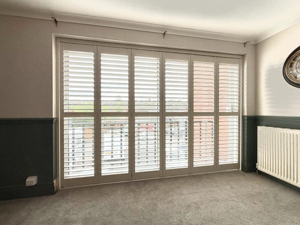 Grey-beige shutters with louvres tilted for daylight