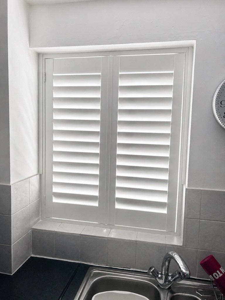 Wednesbury kitchen composite shutters in Silk White, louvres tilted open