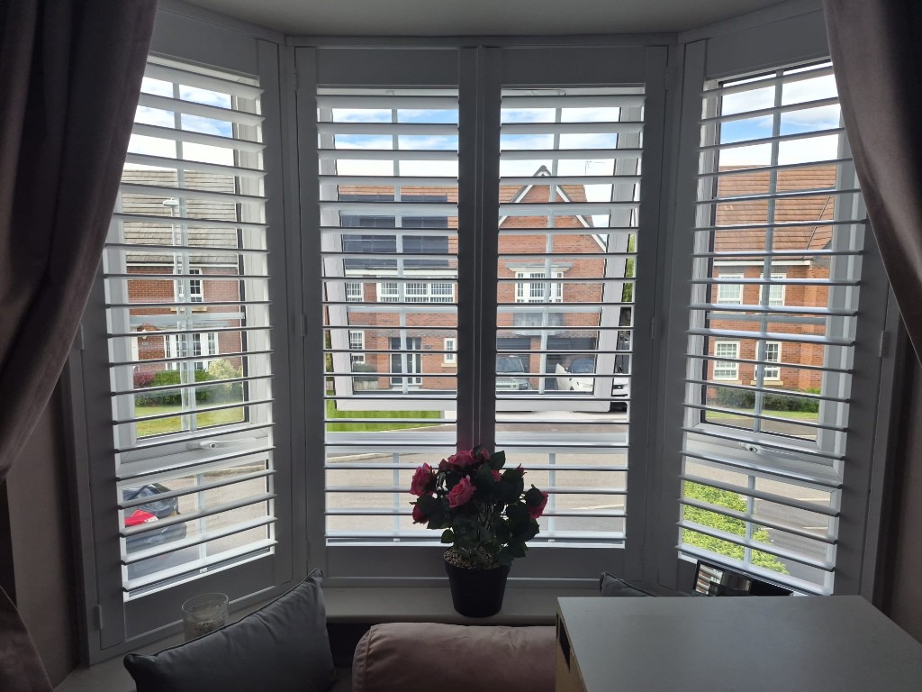 Baggeridge bedroom 2 bay window with four-panel Pure White shutters, louvres tilted open