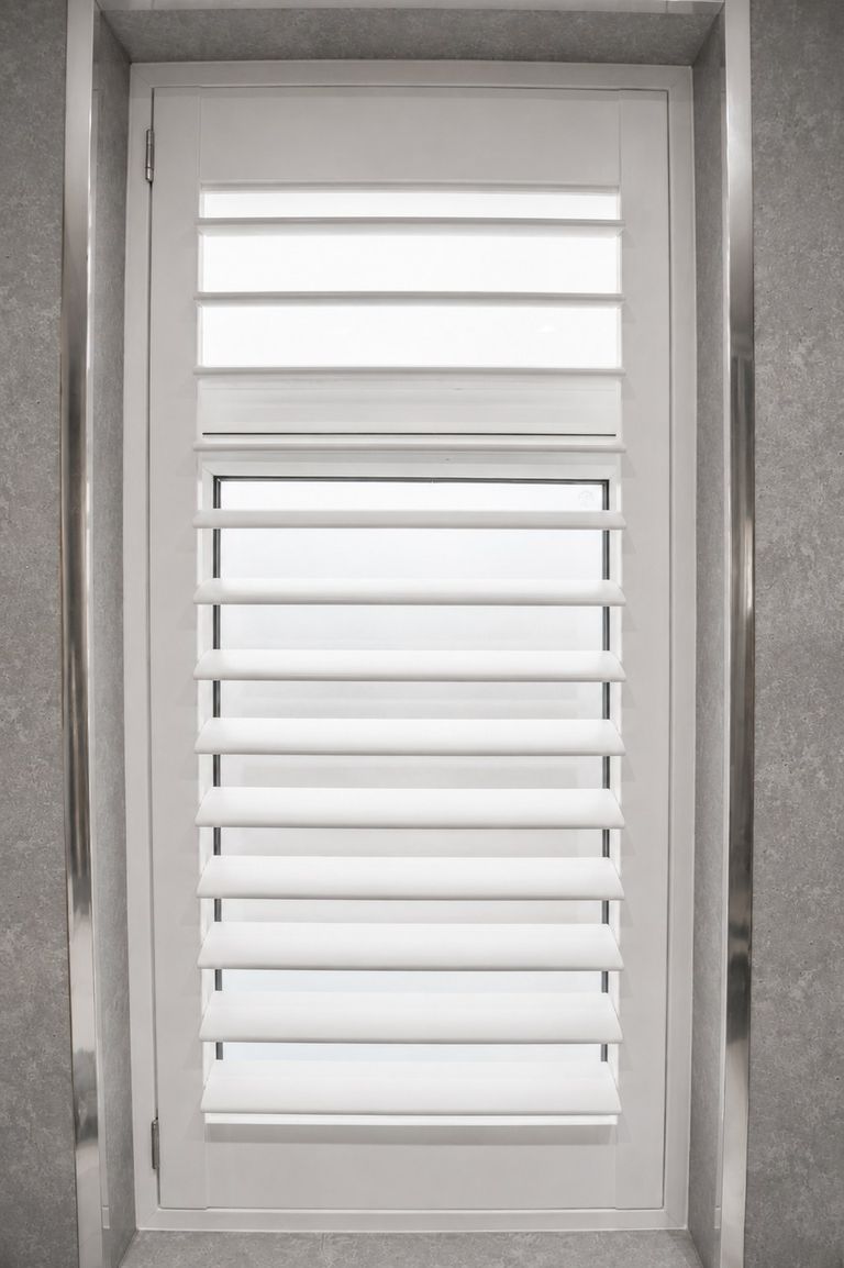 Brierley Hill bathroom with full height Pure White waterproof shutters fitted inside a white tiled window reveal