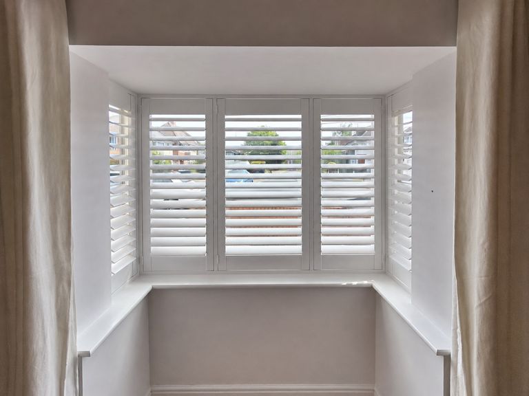 Halesowen dining room box bay with five-panel Pure White shutters, louvres tilted open