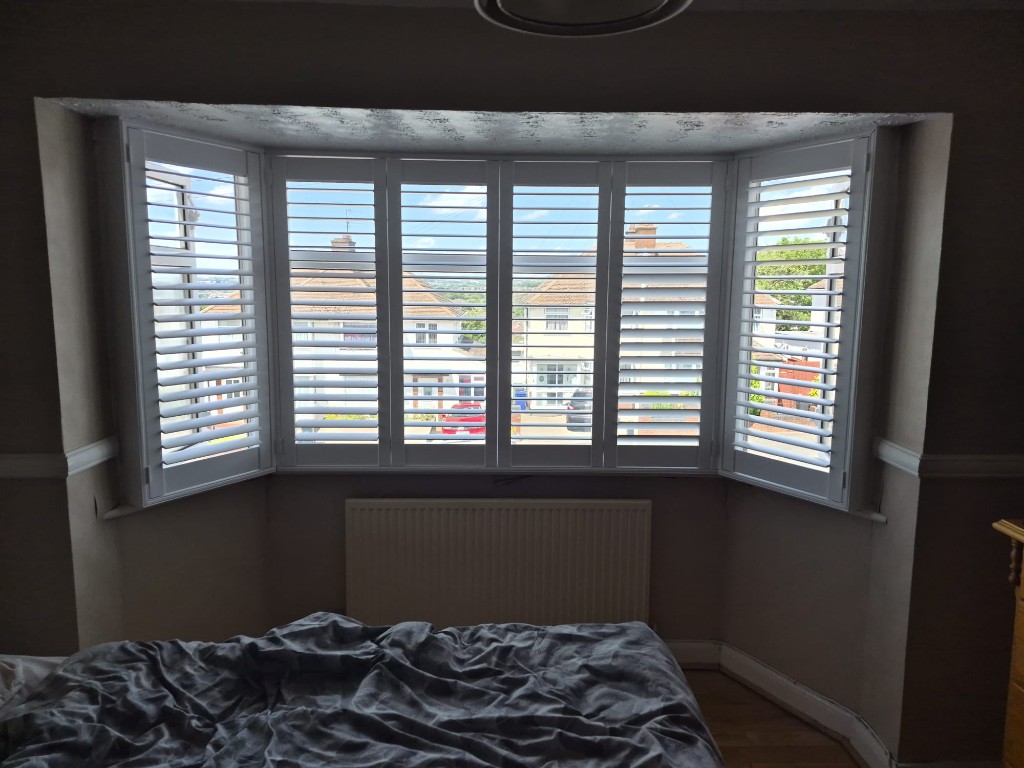 Halesowen upstairs bedroom bay window with six-panel Pure White shutters, split tilt with upper louvres open