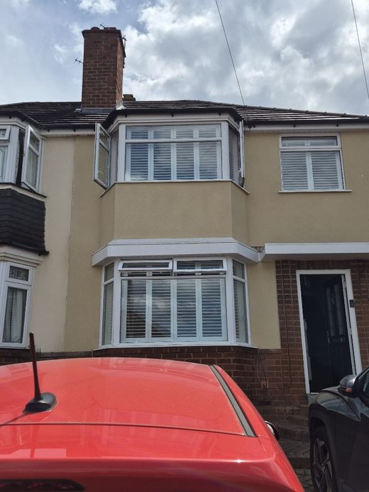 Halesowen semi-detached house front with Pure White full height shutters on the ground floor bay, upstairs bay and side window