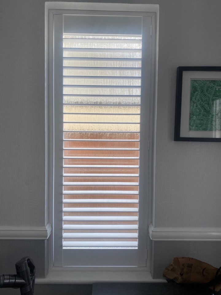 White full height shutter with hidden tilt on a tall narrow window, louvres open