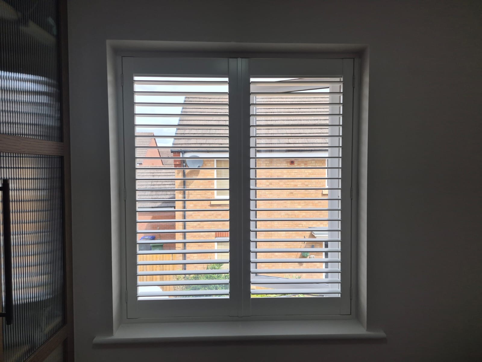 Kingswinford bedroom composite shutters in Silk White with one panel swung open