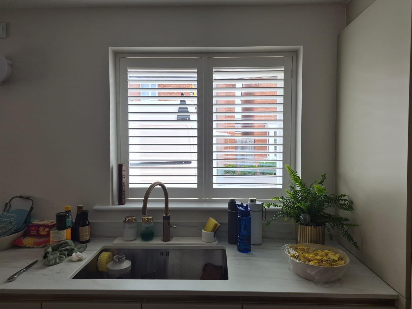 Kingswinford kitchen composite shutters in Silk White, louvres tilted open