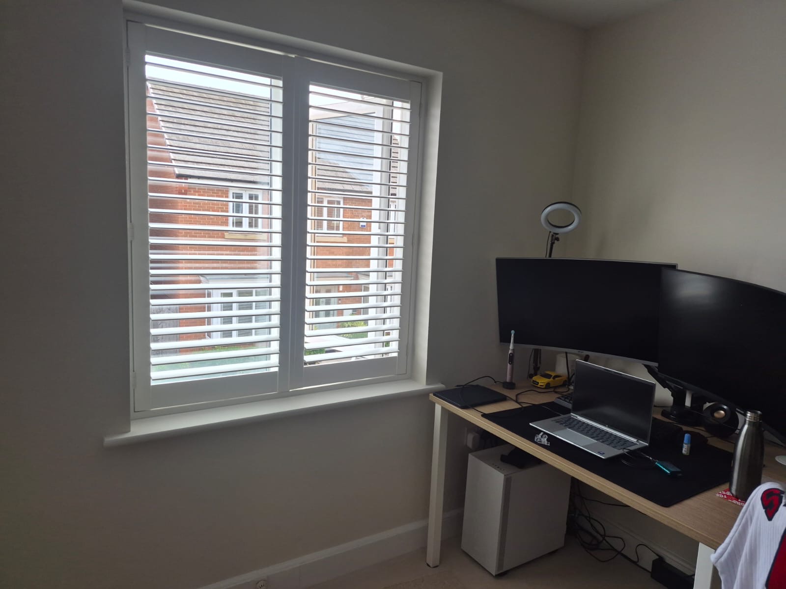 Kingswinford home office with full height composite shutters in Silk White, louvres tilted open above the desk