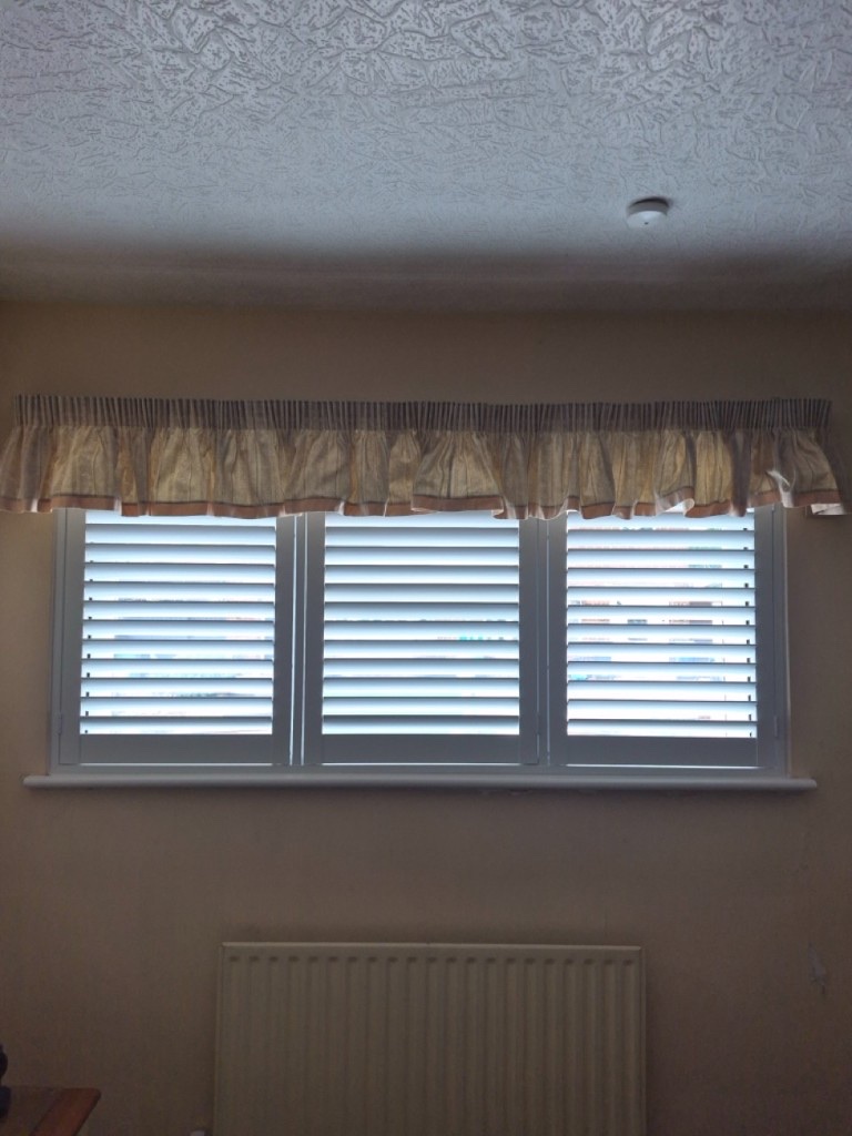 Netherton bedroom Pure White full height composite shutters with louvres open under a fabric valance
