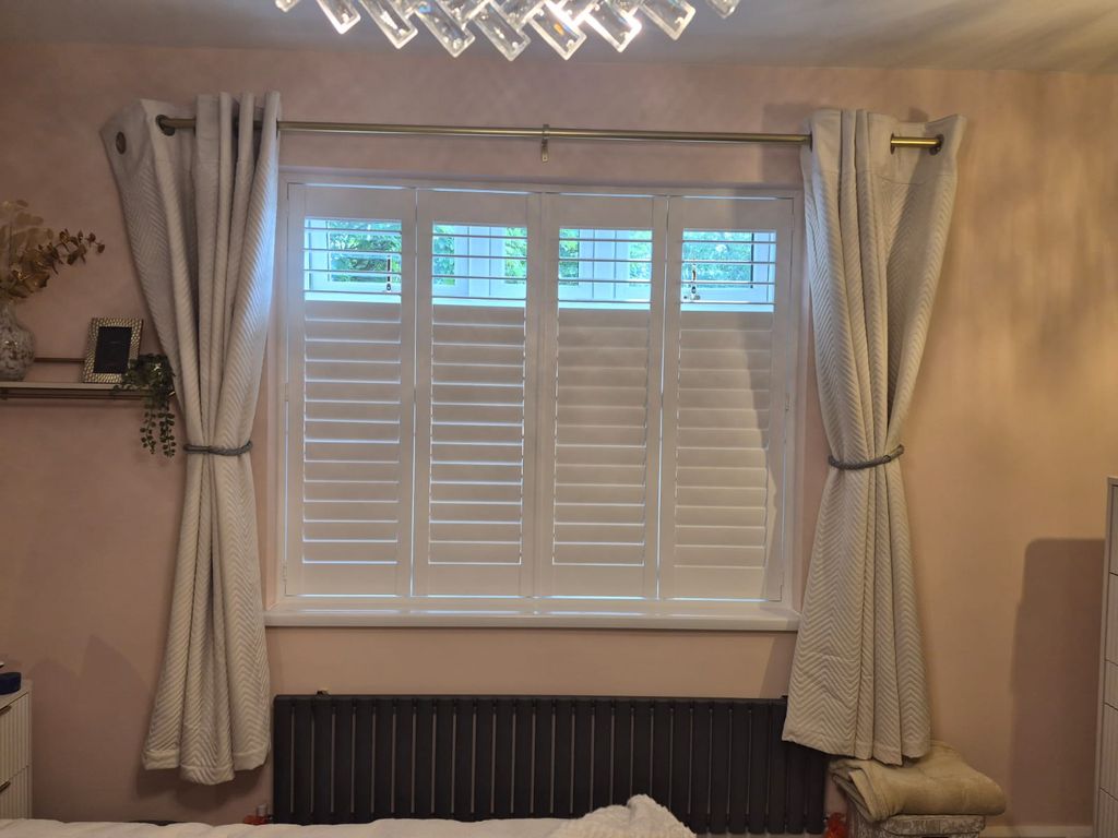 Pure White engineered wood shutters in an Oldbury bedroom with bifolding panels and split tilt