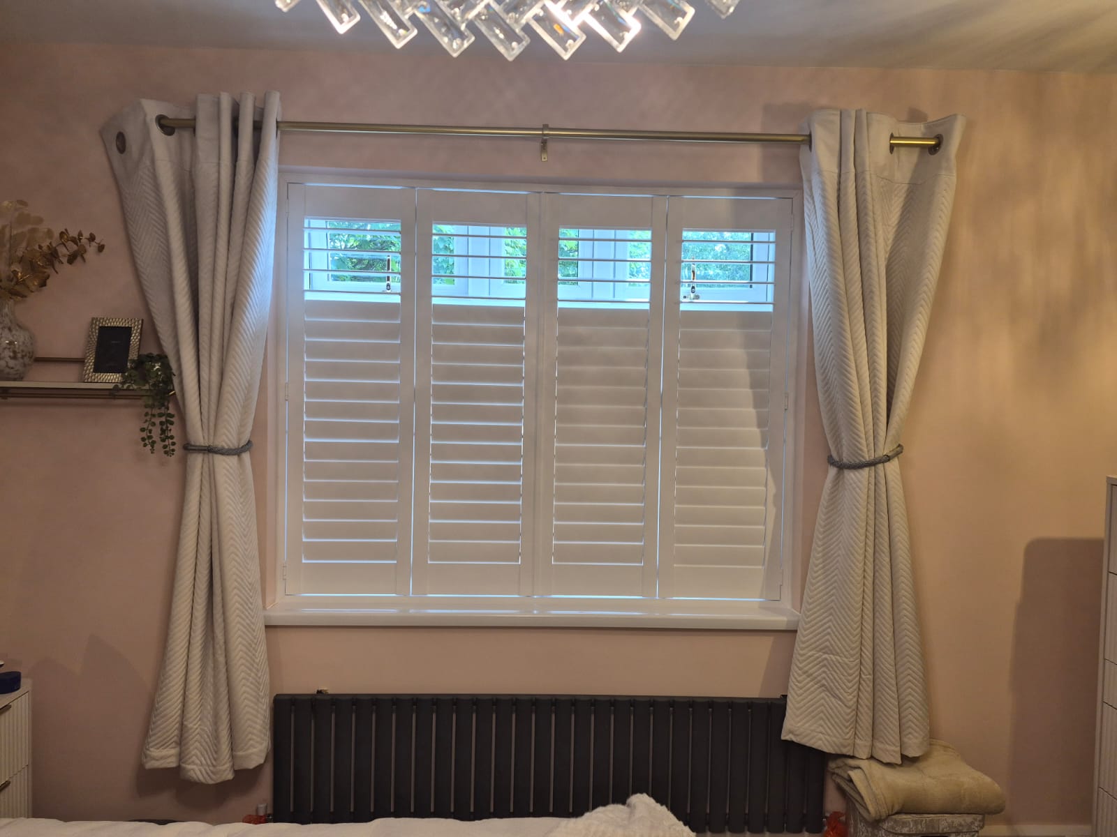 Oldbury bedroom with four-panel bifolding engineered wood shutters in Pure White, louvres tilted open