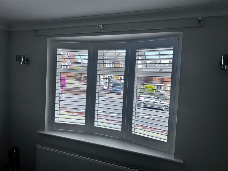 Dining room bay window with three-panel Pure White full height composite shutters, louvres open to the street