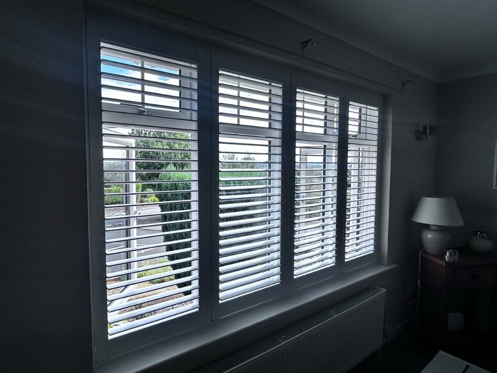 Living room long window with Pure White full height composite shutters, louvres open