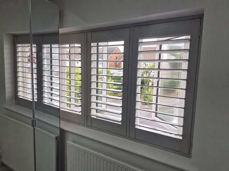 Great Barr bedroom with full height plantation shutters in a soft Sea Mist grey, louvres tilted open