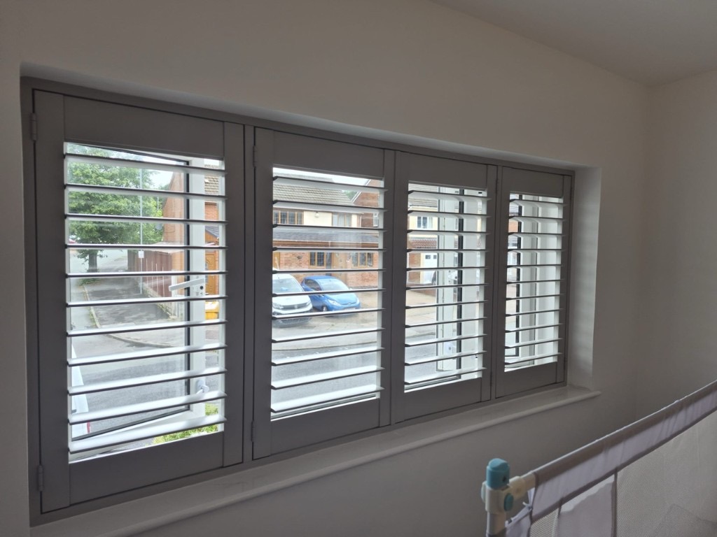 Great Barr bedroom Sea Mist engineered wood shutters with three panels visible, louvres tilted open above a radiator