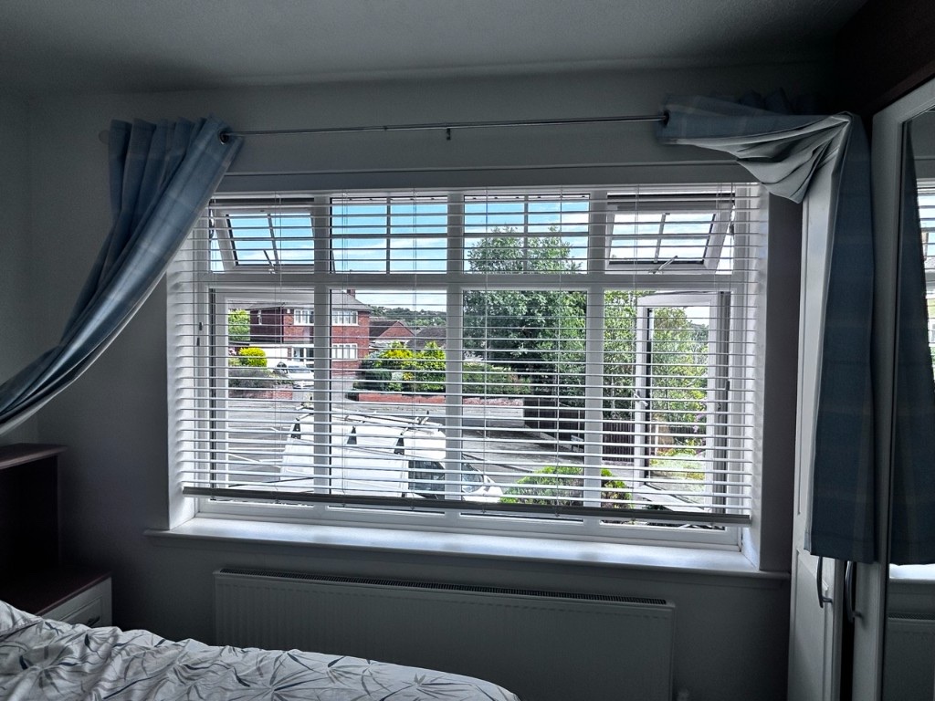 Snow White wood Venetian blinds with 50mm slats on a bedroom window, slats open to the street