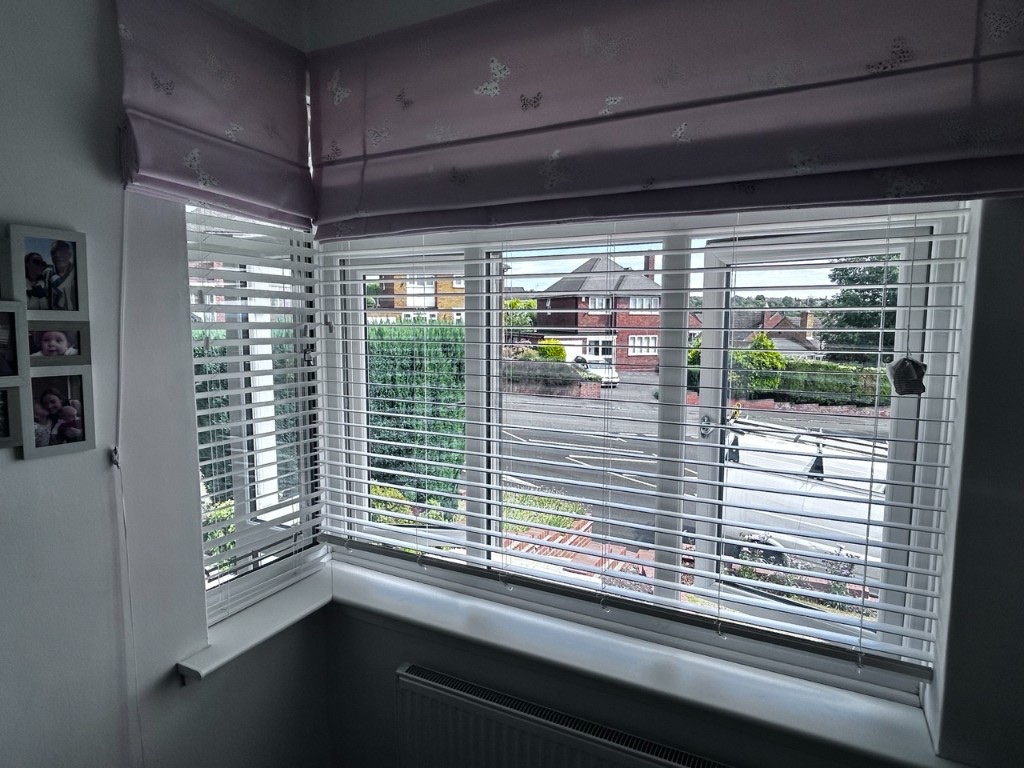 Snow White wood Venetian blinds on a second bedroom corner window, 50mm slats open