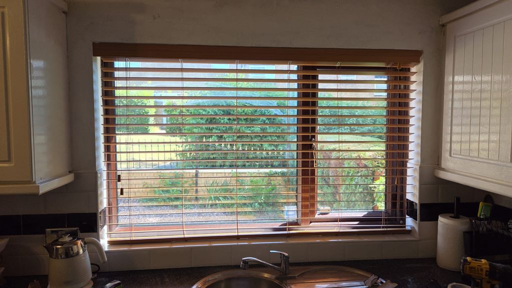 Telford kitchen with Autumn Gold faux wood Venetian blind fitted in the recess above the sink, 50mm slats tilted open to the garden