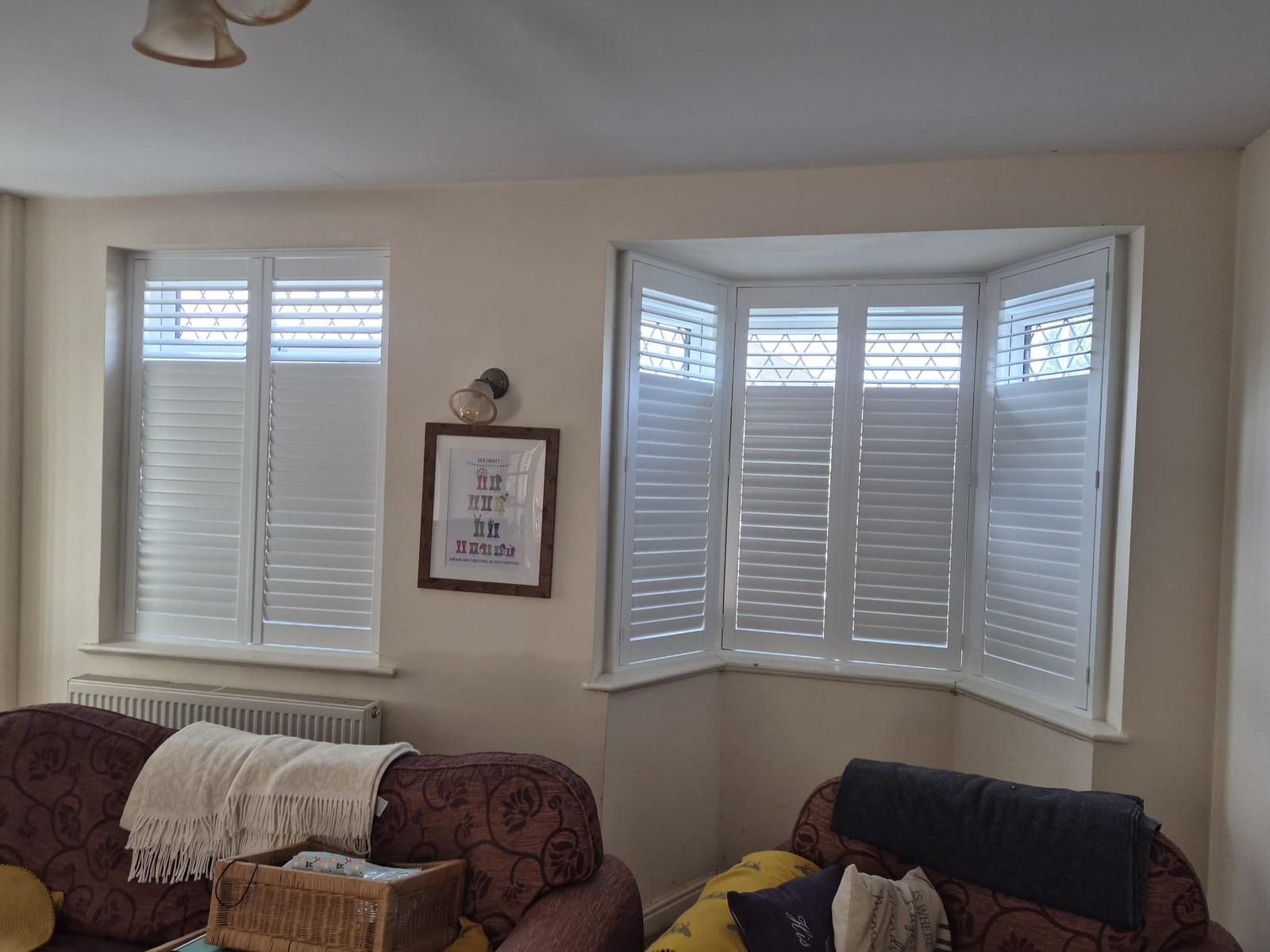 Dudley living room bay with Pure White composite shutters showing split tilt, lower louvres closed and upper louvres open