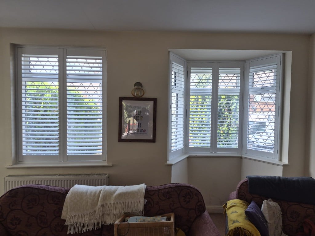 Living room Pure White composite shutters with louvres fully open on flat window and bay