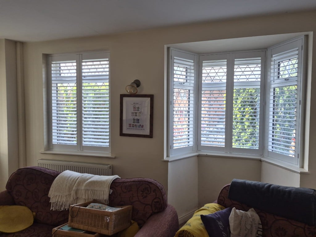 Four-panel bay and flat window in Pure White composite shutters with split tilt louvres