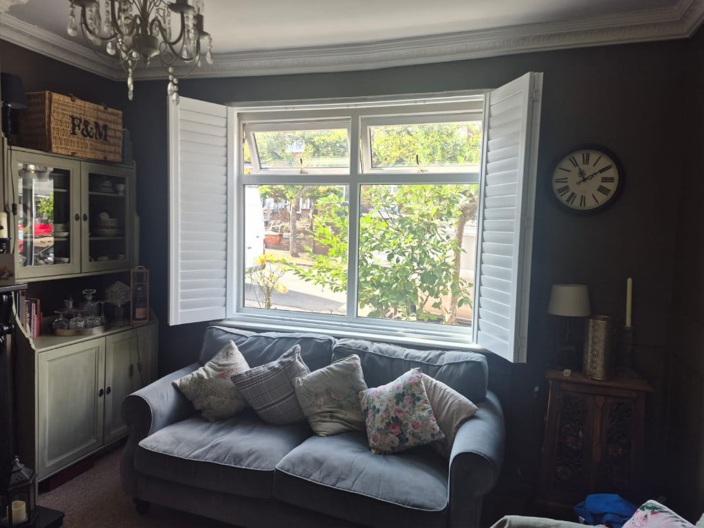 Full Height Composite Bi-folding Living Room Shutters with 76mm Louvres in Pure White. Installed in Penn, Wolverhampton. Open Side On