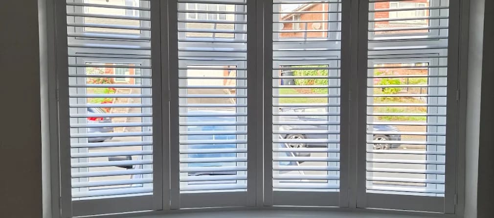 Pure White full height shutters with split tilt on a bay window, louvres open to the street