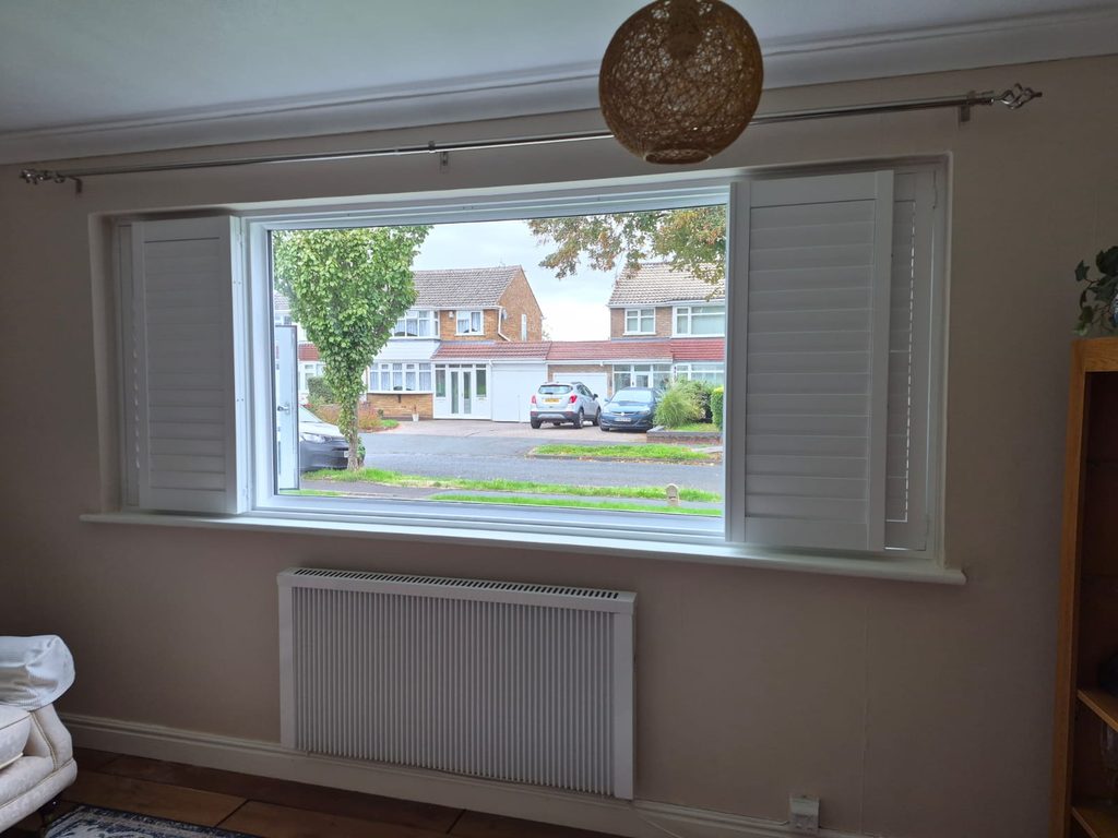 Bifold centre section of Pure White Boston shutters folded back to each side, opening the middle of the window in Tipton