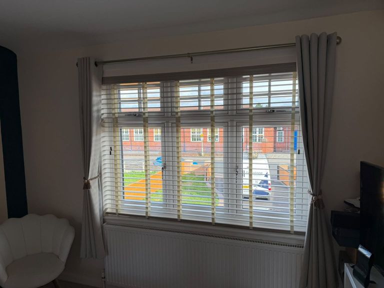 Master bedroom window in Bilston with a 50mm faux wood venetian blind in Greige, slats tilted open to the street