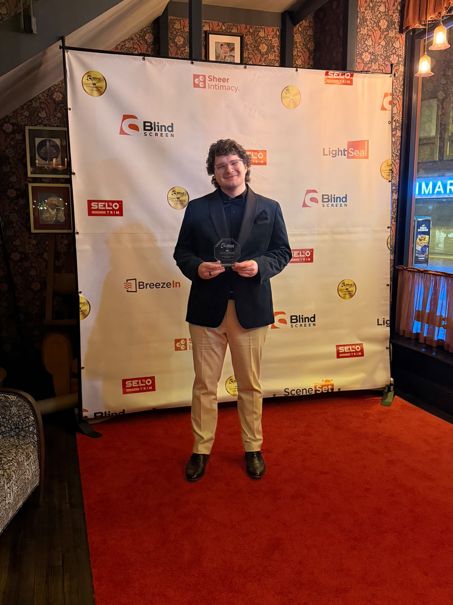 Greystone Shutters team member holding the Blind Screen West Sales Champion award