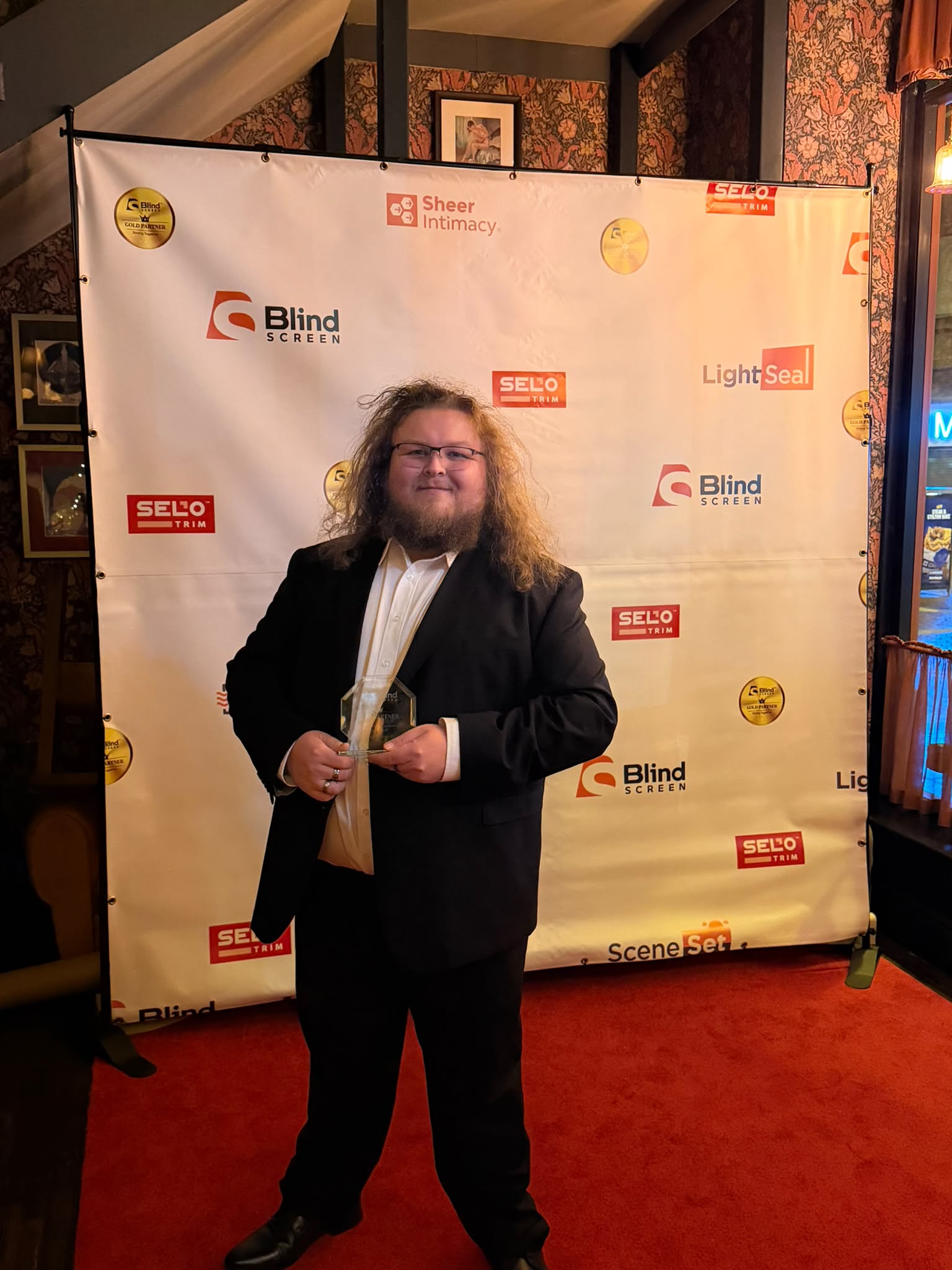 Greystone Shutters team member holding the Blind Screen West Sales Champion award