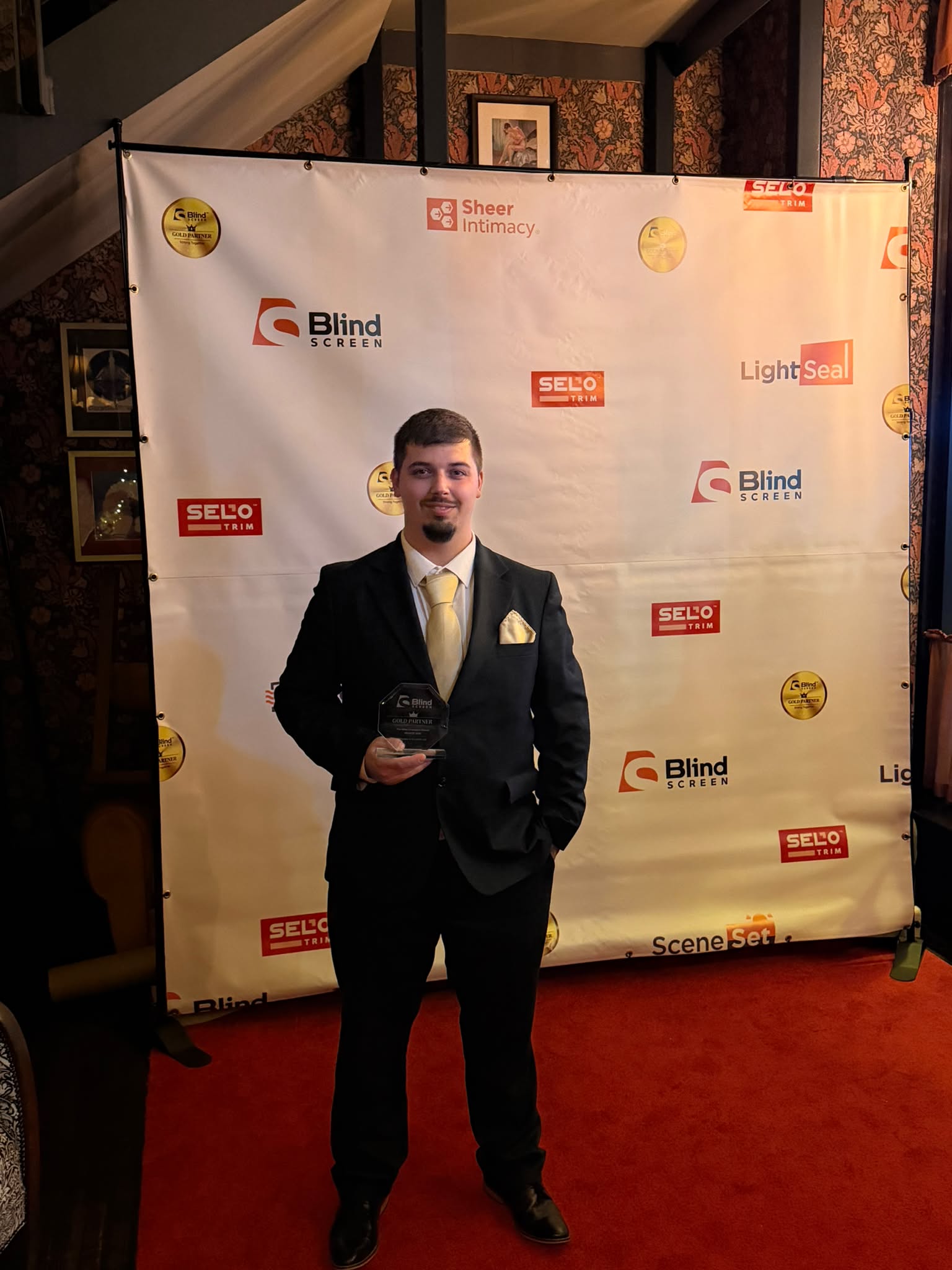 Greystone Shutters team member holding the Blind Screen West Sales Champion award
