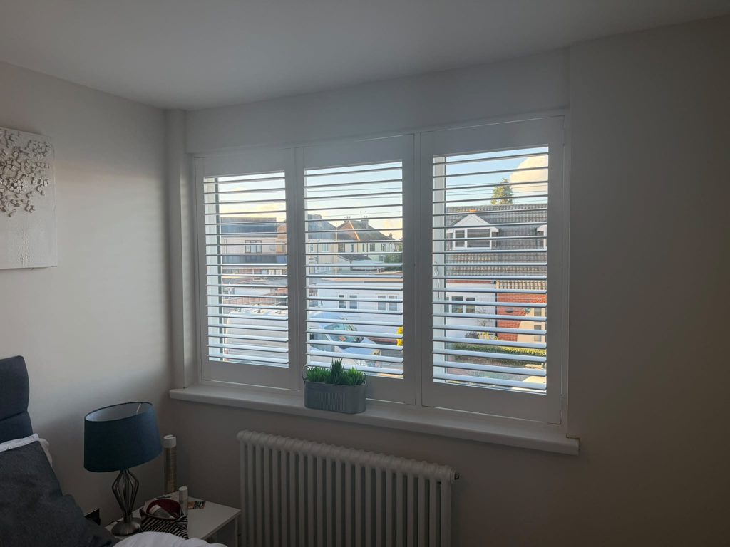 Large Halesowen bedroom window with Pure White full height shutters, louvres open and the street outside