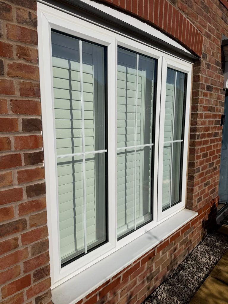 Outside view of the Smethwick ground floor window with the white shutters fully closed behind the glass