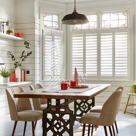 Café style shutters across the lower half of a bright West Midlands window, sunlight pouring in over the top