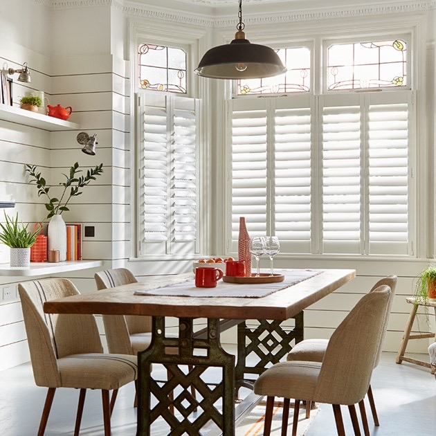 Cafe style shutters letting the morning sun pour over the top into a kitchen